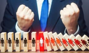 Man is glad that fall of dominoes with people has stopped. Stopping spread of a pandemic corona virus covid-19 through self-isolation of people. Stay home. Universal quarantine and lockdown. Victory