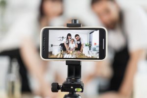 Content creators recording cooking content, using digital tools while showcasing food preparation activities